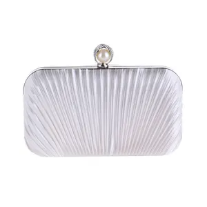 White pleated evening clutch bag detail, elegant pearl rhinestone clasp design for banquet wear.