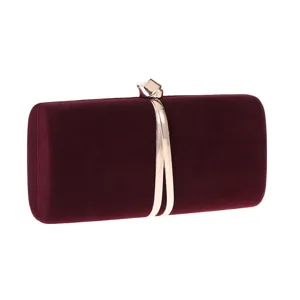 Close-up of a burgundy velvet evening clutch bag with elegant metallic gold clasp detail.