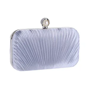 Silver pleated evening clutch bag detail showing delicate fabric texture and pearl clasp.