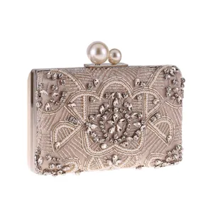 Dettaglio della pochette da sera con perle e strass, borsa in raso champagne con chiusura di perle.