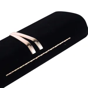 Close-up of velvet evening clutch bag, black hard box purse detail with gold metal decor.