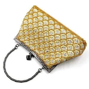 Detailed view of gold beaded sequin evening clutch bag with fish scale pattern and metal handle.