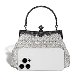 Sparkling crystal evening bag detail featuring ornate black metal handle and beads.