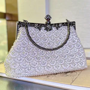 Close-up detail of vintage beaded evening clutch bag with intricate fish scale pattern metal frame