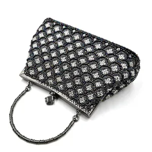 Detailed close-up of the beaded evening clutch with shimmering fish scale pattern and metal handle.