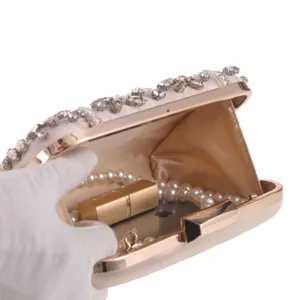 Elegant beaded evening clutch bag detail view, showing spacious interior with pearl necklace.