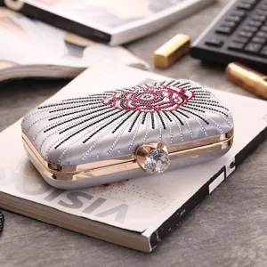 Detailed shot of silver rhinestone evening clutch bag with crystal clasp and metallic frame.