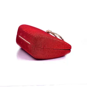 Red glitter evening clutch bag detail showing sparkle fabric and crystal rhinestone clasp.
