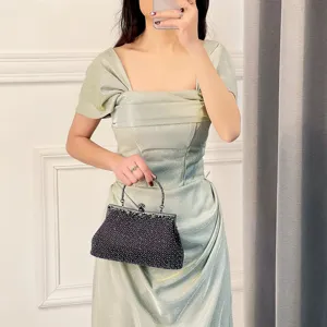 Exquisite dark beaded evening bag detail, sparkling pearl clutch with metal clasp and handle.