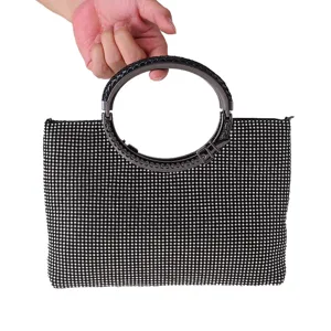 Black rhinestone evening handbag with stylish round metal handle for party and event detail.