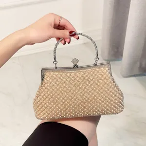 Detailed view of elegant pearl evening clutch bag with metallic clasp handle for women parties.