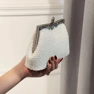 Exquisite white pearl beaded evening clutch bag with ornate metal frame and clasp for party.