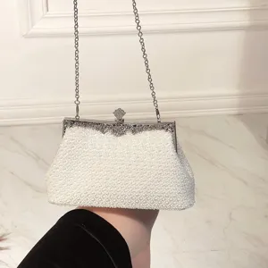 White pearl evening clutch bag with metal frame kiss-lock and chain strap for women.
