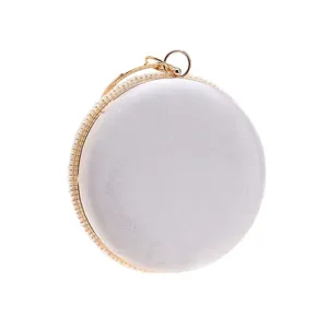 Detailed view of round pearl evening clutch bag with satin finish and elegant gold ring handle.