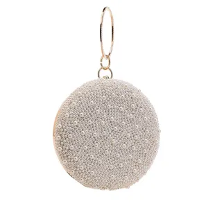 Detailed view of women round pearl evening bag with gold metal ring handle and luxury style.