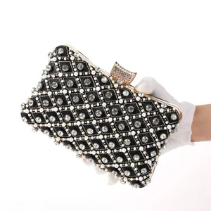 Detail view of black rhinestone evening clutch bag with pearl grid and metal clasp frame.