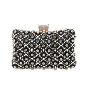 Detailed view of luxury black evening clutch bag with sparkling rhinestones and pearl embellishments.