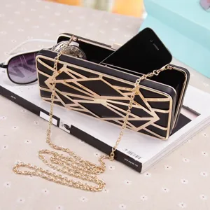 Detailansicht der schwarz-goldenen geometrischen Clutch Abendtasche für Damen.