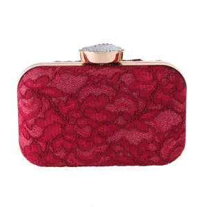 Detalle de bolso de mano de encaje rojo con textura floral delicada y cierre de cristal.