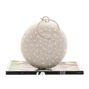 Elegant round pearl evening clutch bag with sparkling rhinestone metal ring handle for women.