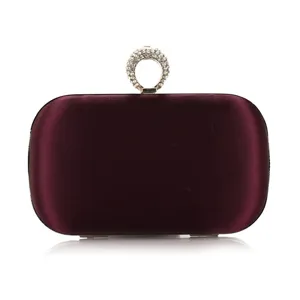 Detailed view of dark burgundy velvet evening clutch bag with elegant rhinestone ring clasp.