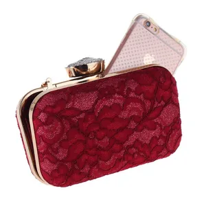 Elegante bolso de mano de noche en encaje rojo con marco dorado y cierre de estrás para fiesta.