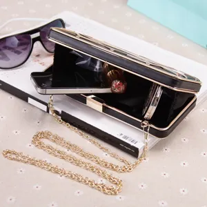 Elegante schwarze Abendtasche Clutch mit Goldkette und ausgehöhltem Metallrahmen für Damen.