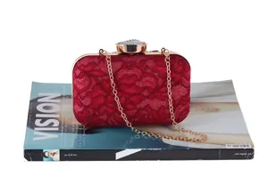 Elegante bolso de noche de encaje rojo con cadena dorada y cierre de estras para fiestas.