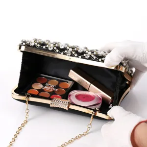 Detail view of the black evening clutch interior, featuring pearl and crystal rhinestone decor.