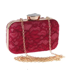 Bolso de noche de encaje rojo con cadena dorada y elegante cierre de gema.