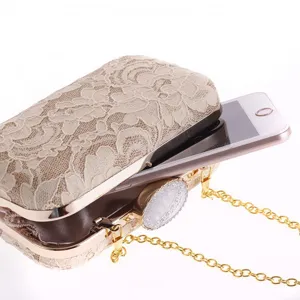 Elegante bolso de noche de encaje beige con correa de cadena dorada y cierre de diamantes.