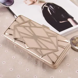 Nahaufnahme einer schicken Champagner Abendtasche mit geometrischem Goldmetall-Design.
