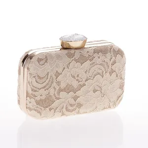 Elegante bolso de mano de encaje beige con marco dorado y brillante cierre de pedrería.