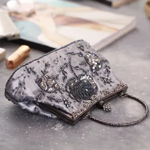 Close-up of vintage grey beaded evening clutch with exquisite rose embroidery and metal handle.