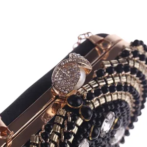 Close-up detail of luxury beaded rhinestone evening clutch bag with gold hardware.