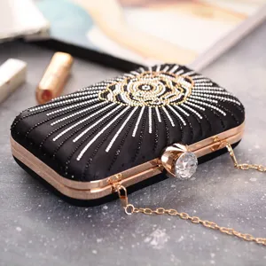 Detail shot of black rhinestone evening clutch bag with rose gold frame and crystal clasp.