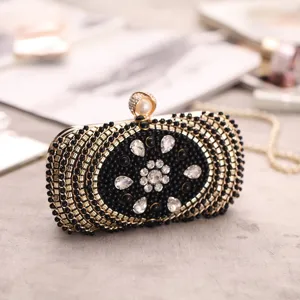 Elegant black and gold evening clutch bag with sparkling rhinestones, pearls and delicate beads.