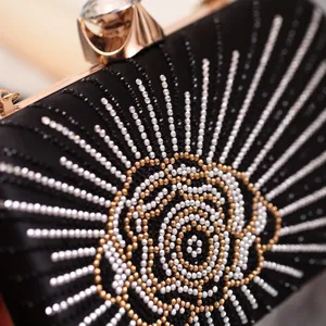 Elegant black rhinestone evening clutch bag with sparkling crystal clasp and gold metal frame.
