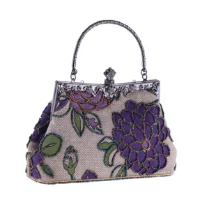 Close-up of vintage beaded evening bag with exquisite purple floral embroidery and metal handle.