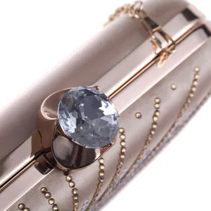 Elegant champagne satin evening clutch bag with crystal lock and diamond details for women.
