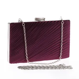Wine red pleated evening clutch bag detail, featuring silver chain and crystal clasp.