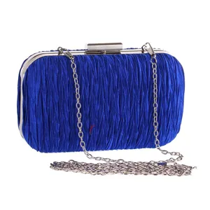 Detail van de blauwe geplooide avondtas met delicate stoffen plooien en gepolijst zilveren frame.
