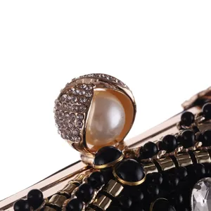 Stunning evening clutch detail featuring a pearl clasp, shimmering rhinestones, and black beads.