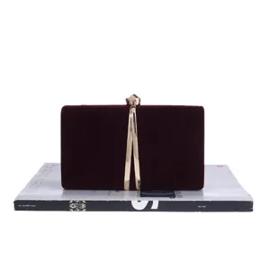 Burgundy velvet evening clutch bag detail view, elegant gold clasp and metal front decor.