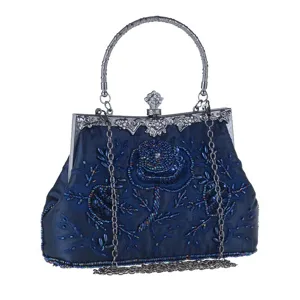 Close-up of vintage dark blue satin beaded evening bag with floral embroidery and metal frame.