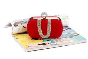 Detailed view of red velvet evening clutch featuring dazzling rhinestones and unique ring clasp.