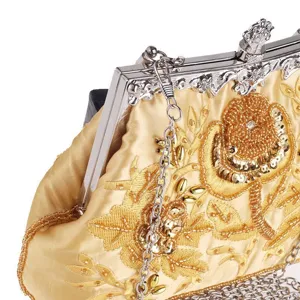 Detailed view of gold satin evening bag with intricate bead embroidery and silver clasp.