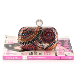 Details of sequin evening clutch bag with sparkling crystal ring clasp and colorful pattern.