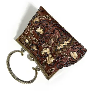 Vintage beaded evening bag detail, metallic scroll handle, elegant bronze sequin embroidery.