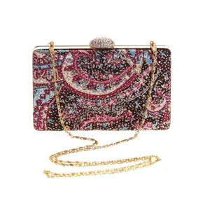 Detailed view of the elegant rhinestone clasp and gold chain strap on the printed evening clutch.